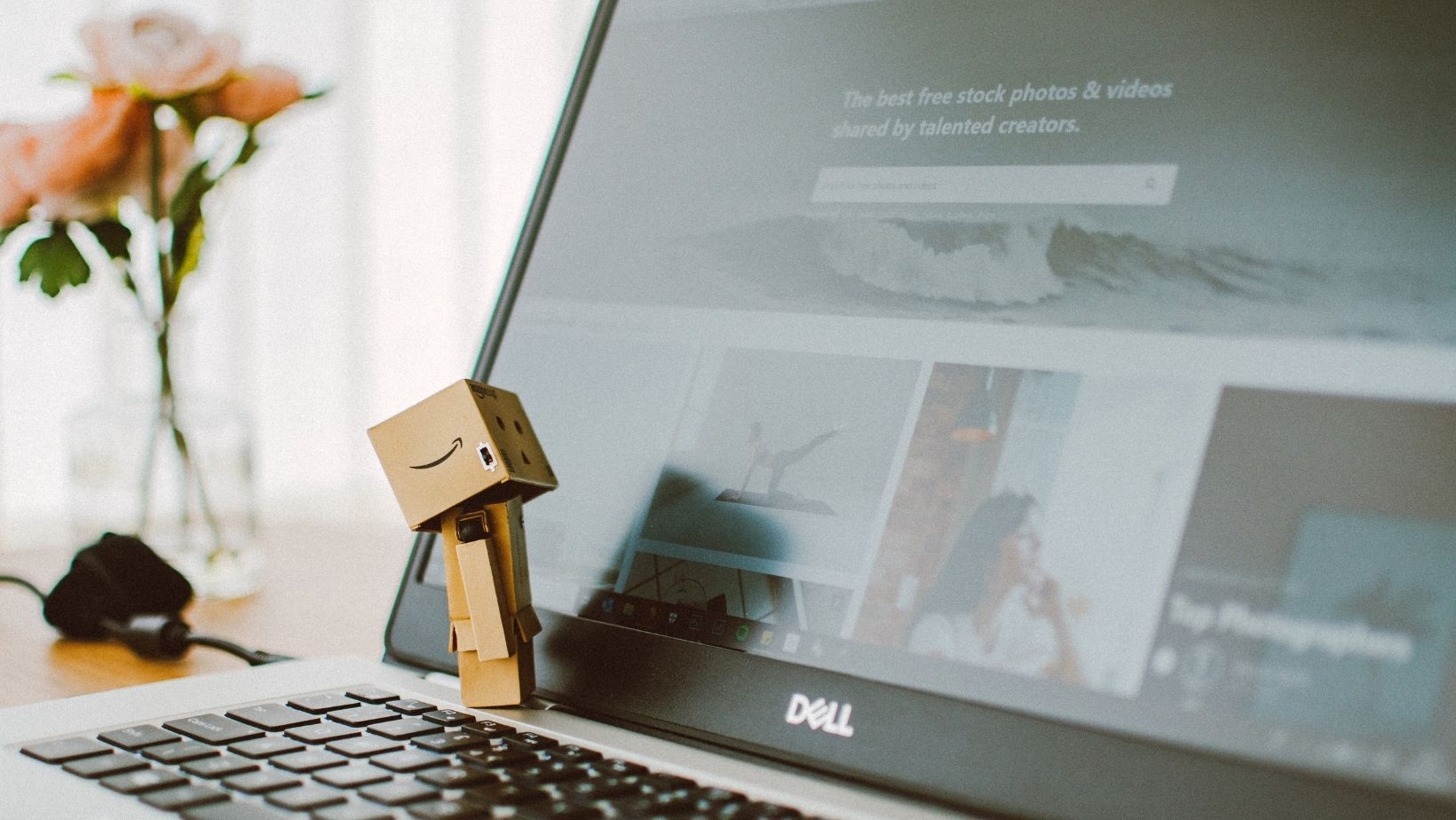 a laptop with a wooden Amazon figurine resting on top