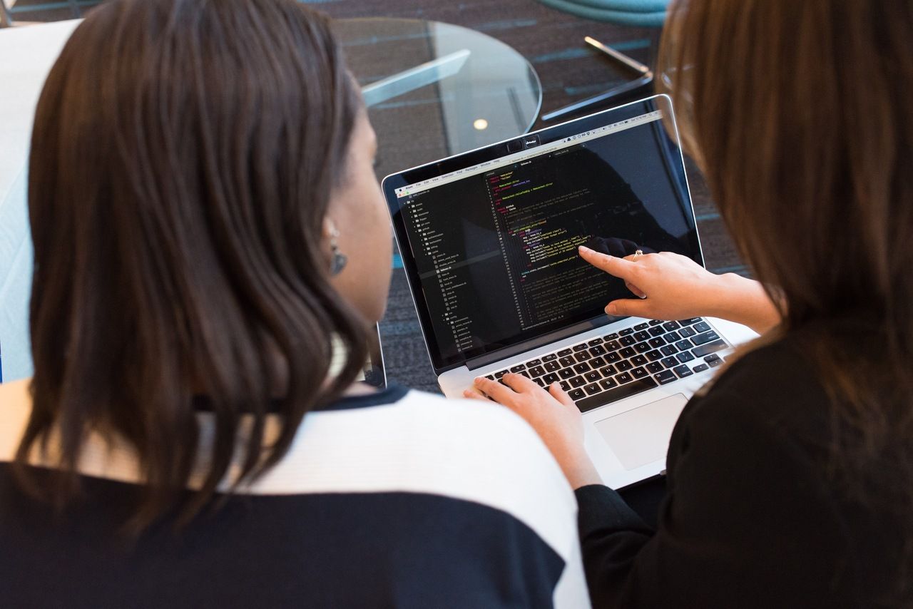 two women developer talking about code